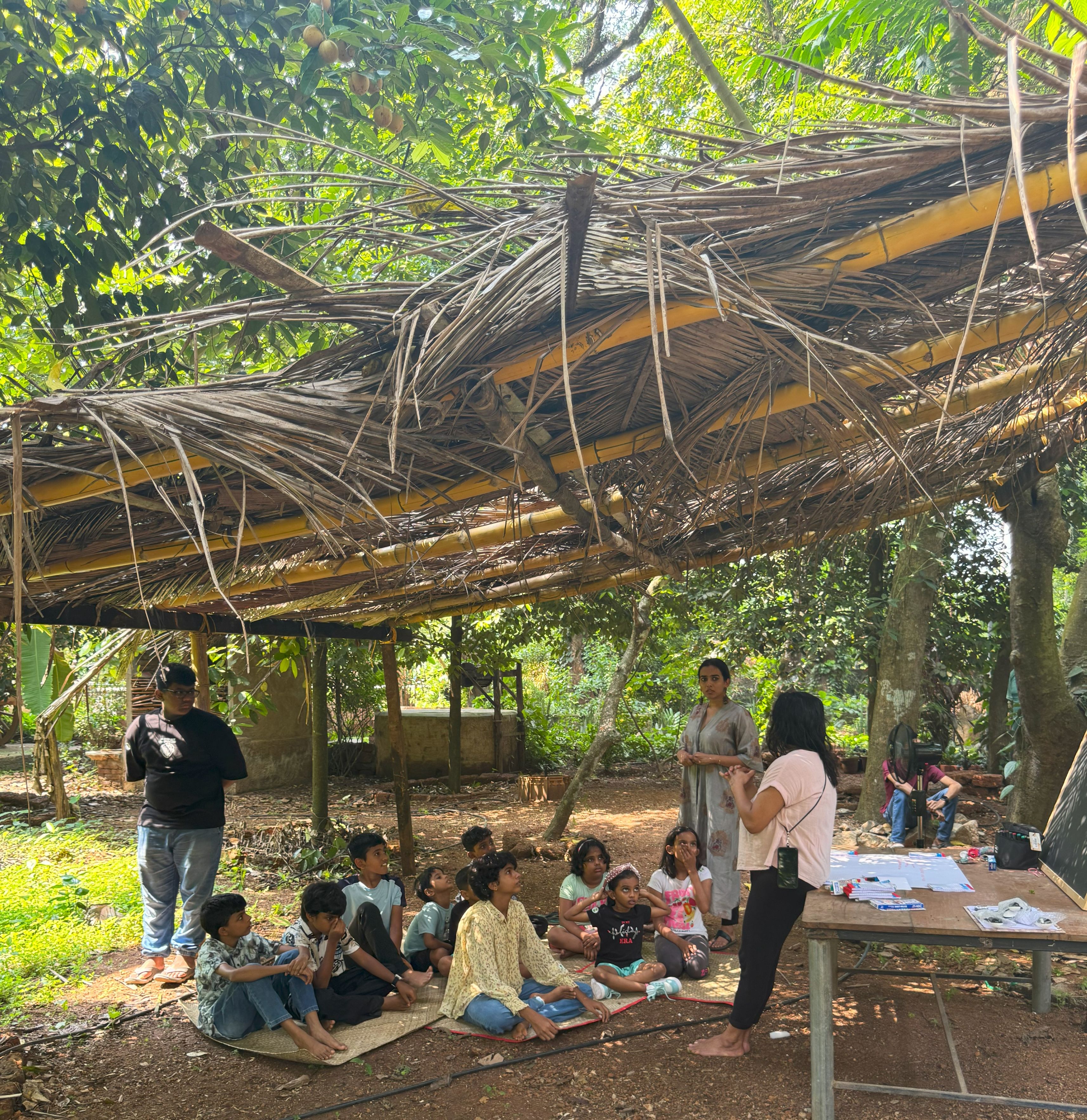 Summer camp team sitting under a makeshift shade